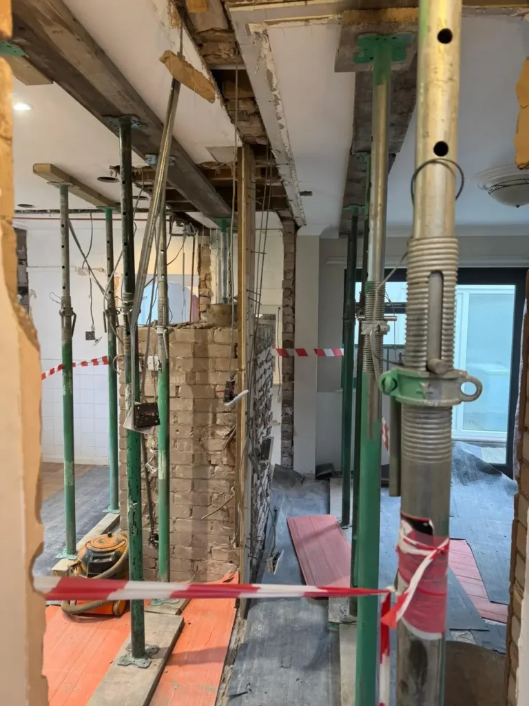 Structural support installation using props during a renovation project in Flintshire.
