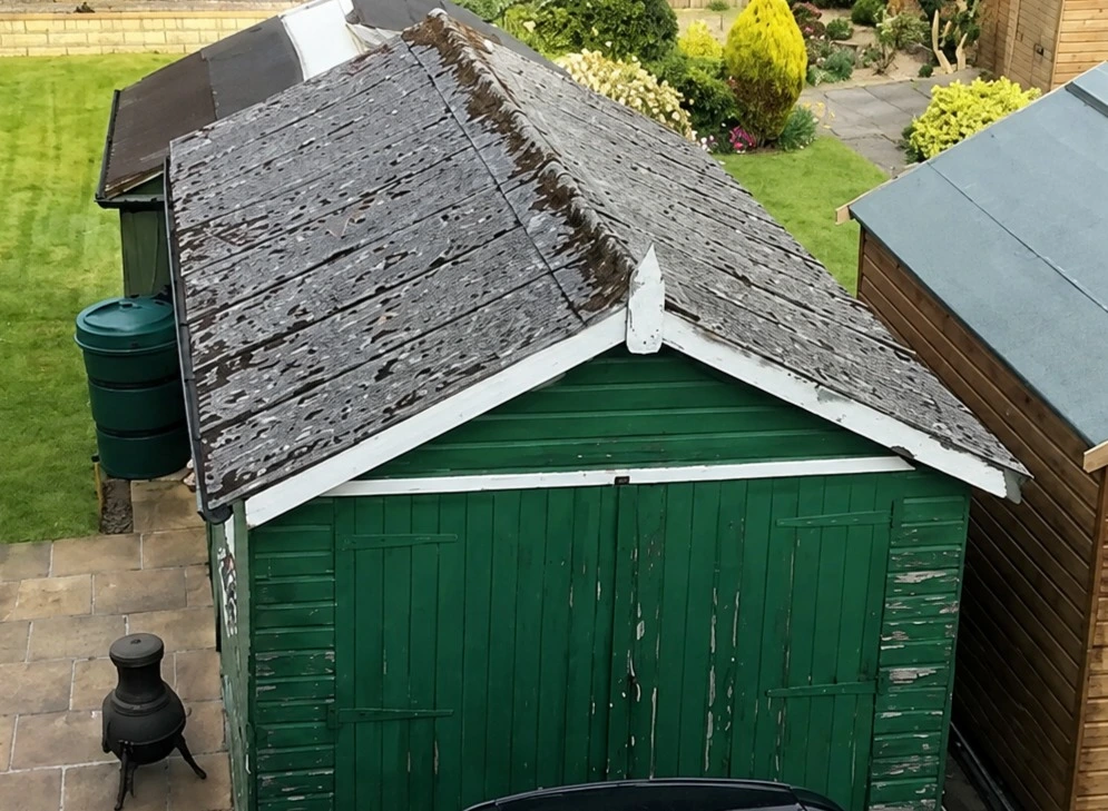 Before garage demolition in Flintshire showing detached concrete garage before demolition by Quirks Property Maintenance Ltd.