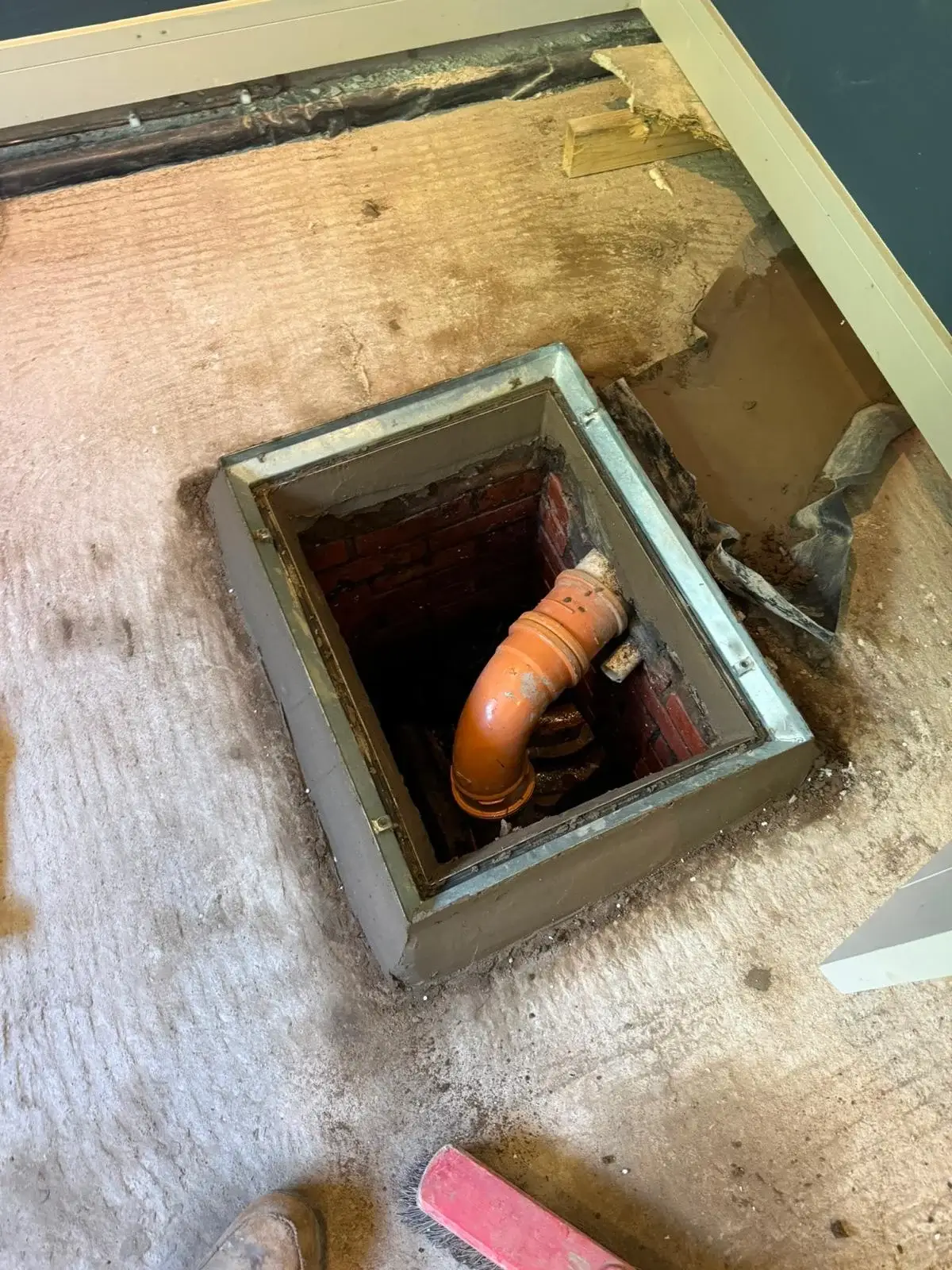 Emergency builder exposing damaged drainage inspection chamber in Flintshire