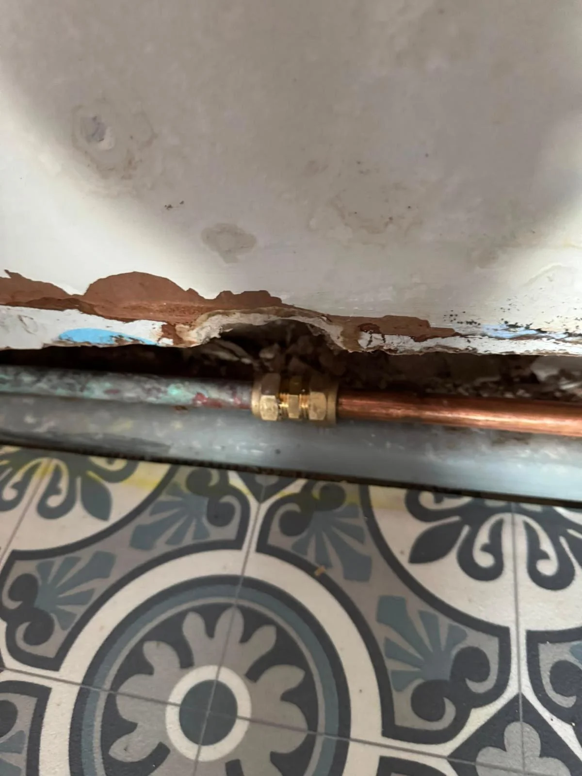 New copper pipe section joined to corroded original pipework with brass compression couplings at floor level