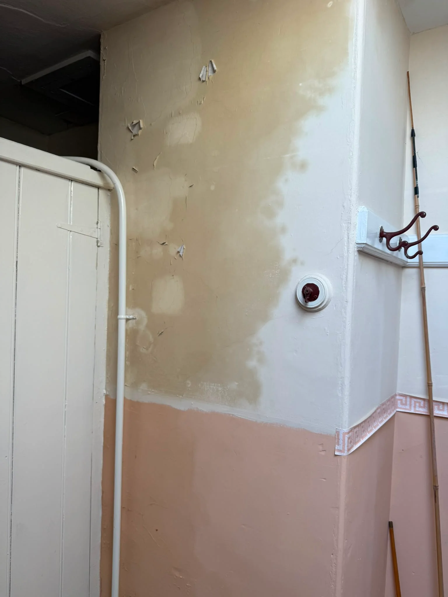 Peeling paint and damp damage to internal wall at Wirral property