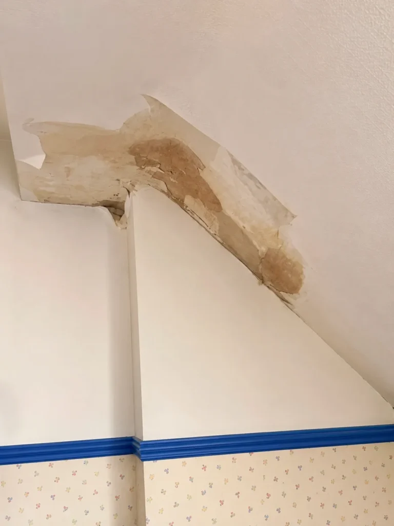 Water ingress damage to bedroom wall and ceiling at Wirral property