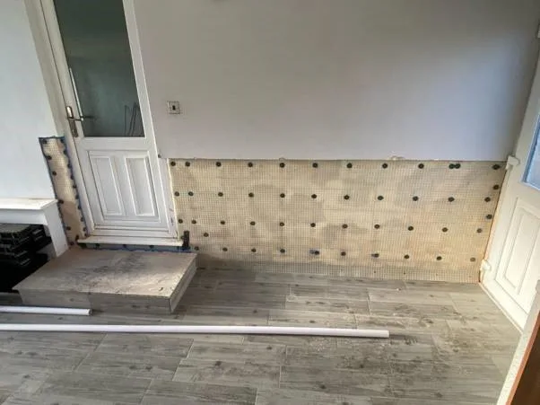 Studded damp proof membrane fitted to a wall beside a doorway