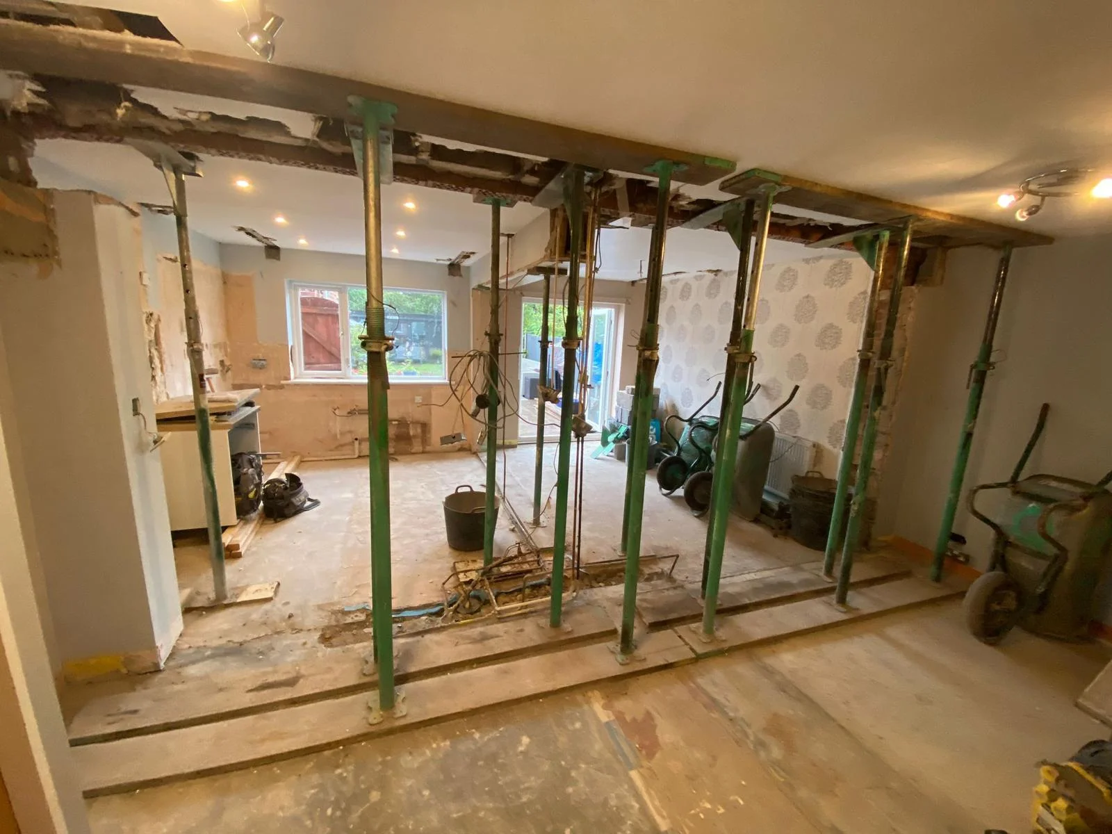 Structural load-bearing wall removal and steel beam installation during a home alteration project.