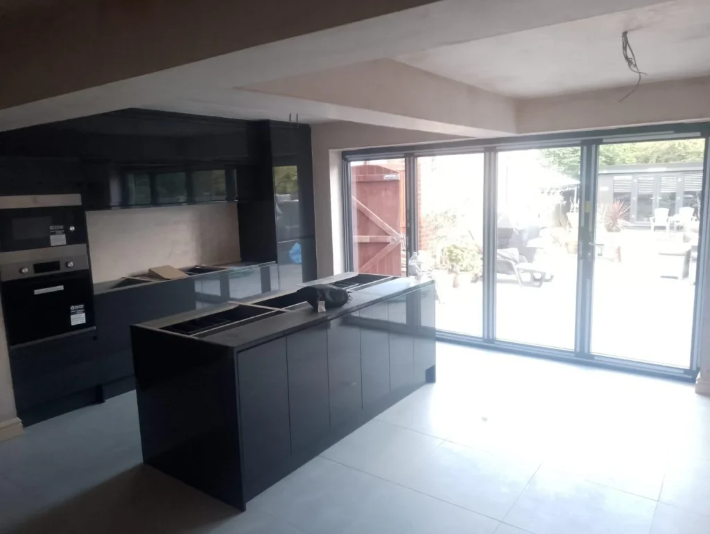 Completed open-plan kitchen renovation with bi-fold doors and modern structural steel finish.
