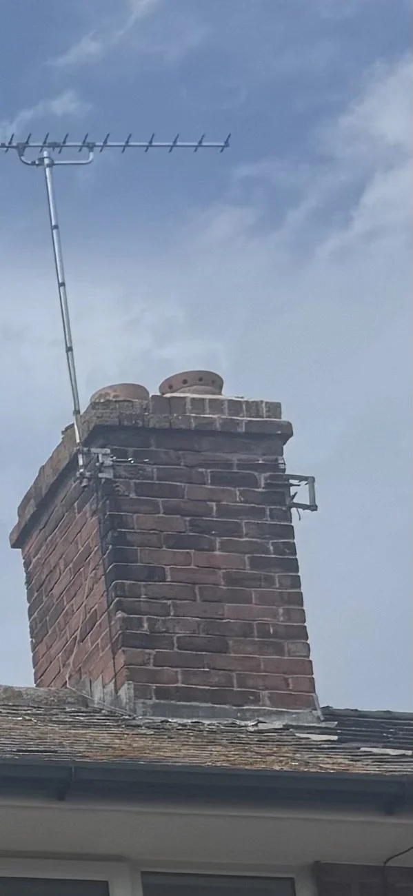Brick chimney stack with clay pots and defective flaunching on a terraced house in Deeside, Flintshire, inspected for a pre-purchase repair quotation