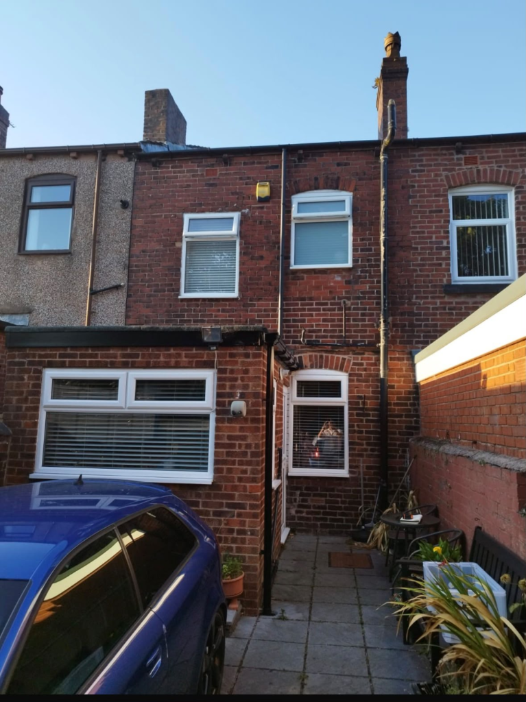 Rear elevation of a terraced house in Hightown, Wrexham before repointing, with mortar missing from the joints