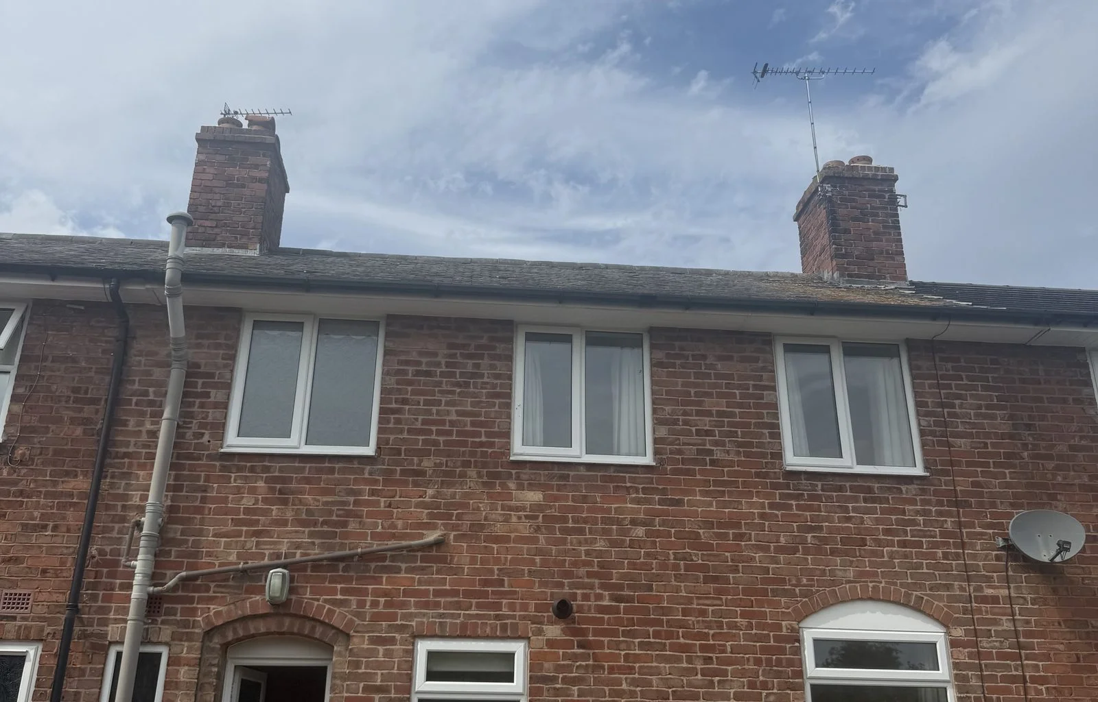 Shared chimney stacks and thin slate roof covering to the rear elevation of a terraced property in Deeside, Flintshire