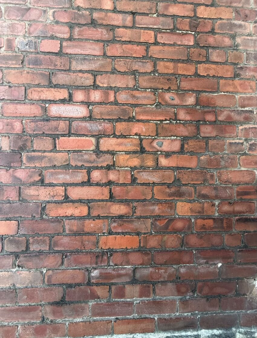 Weathered brickwork with recessed and open mortar joints before lime repointing