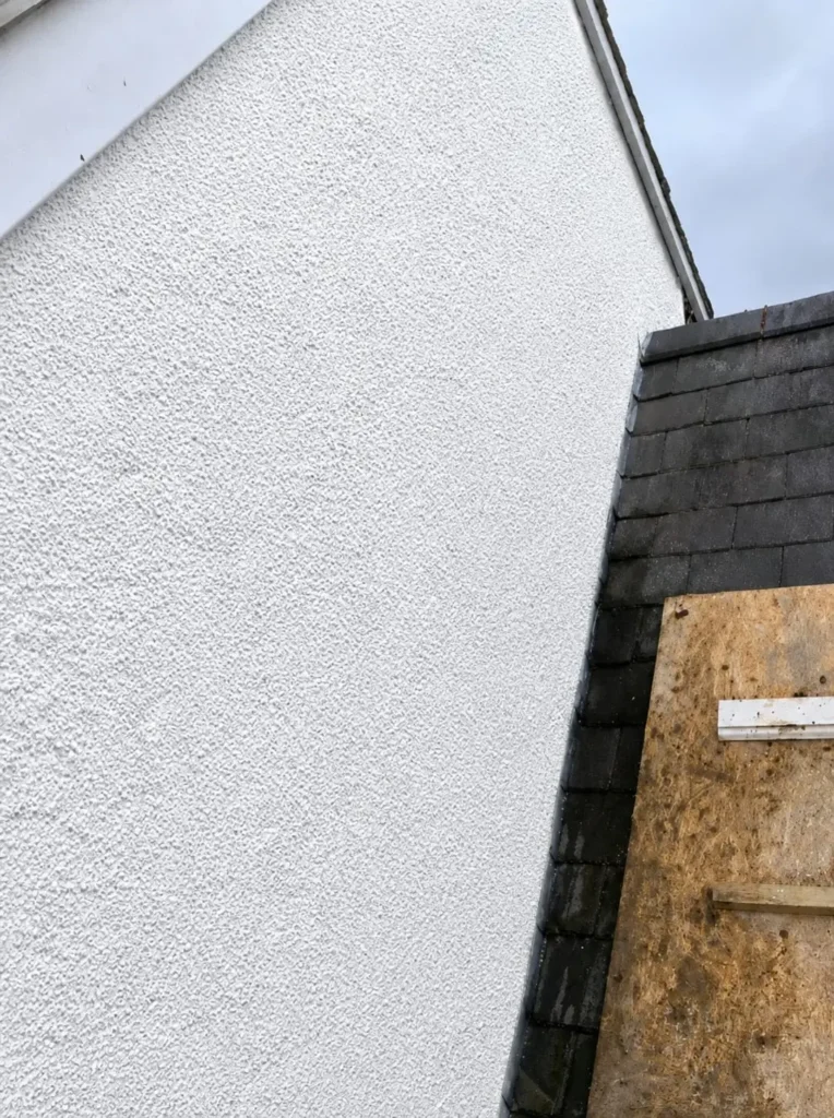 Completed external rendered wall following structural crack repairs and remedial building works in Hope, Flintshire