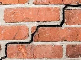 Stepped crack running through failed mortar joints in a brick wall