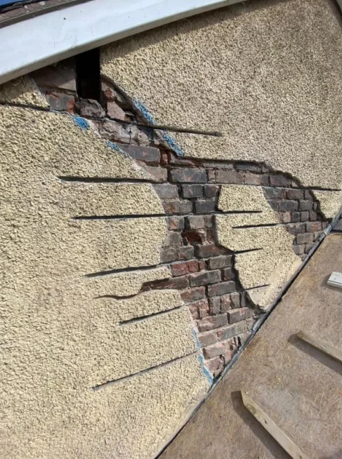 Helical bar crack stitching installed to external rendered wall during structural repairs in Hope, Flintshire