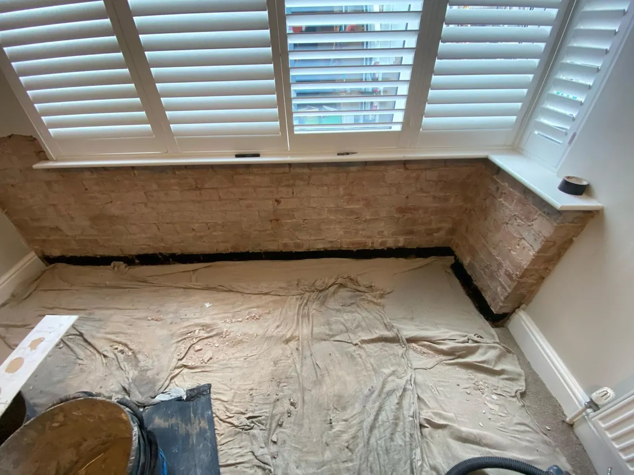 Bay window walls stripped back to brick during damp proofing in Chester