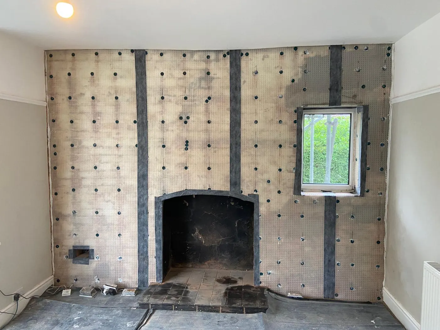 Damp-proof membrane fixed to the chimney breast during damp proofing in Flintshire