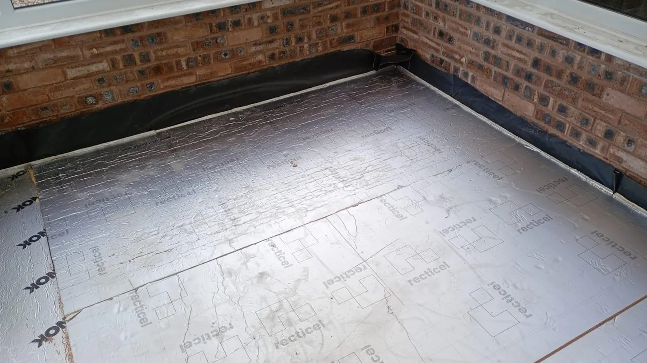 Silver-faced floor insulation boards laid during damp proofing floor renewal in Chester