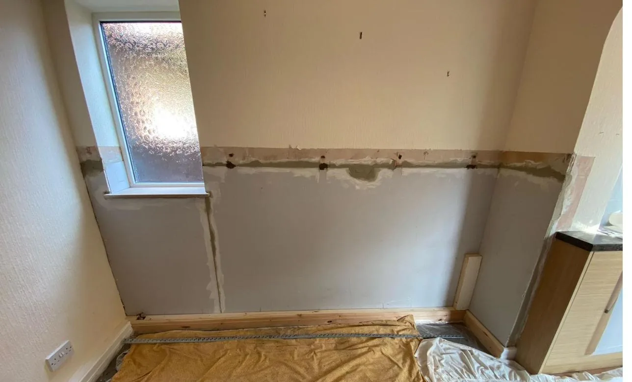 Reinstated wall with new skirting after damp proofing in Deeside
