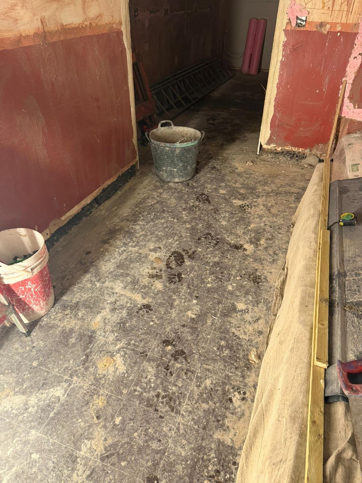 Existing concrete floor slab of a Flintshire house stripped of its coverings during renovation before liquid damp-proof membrane treatment