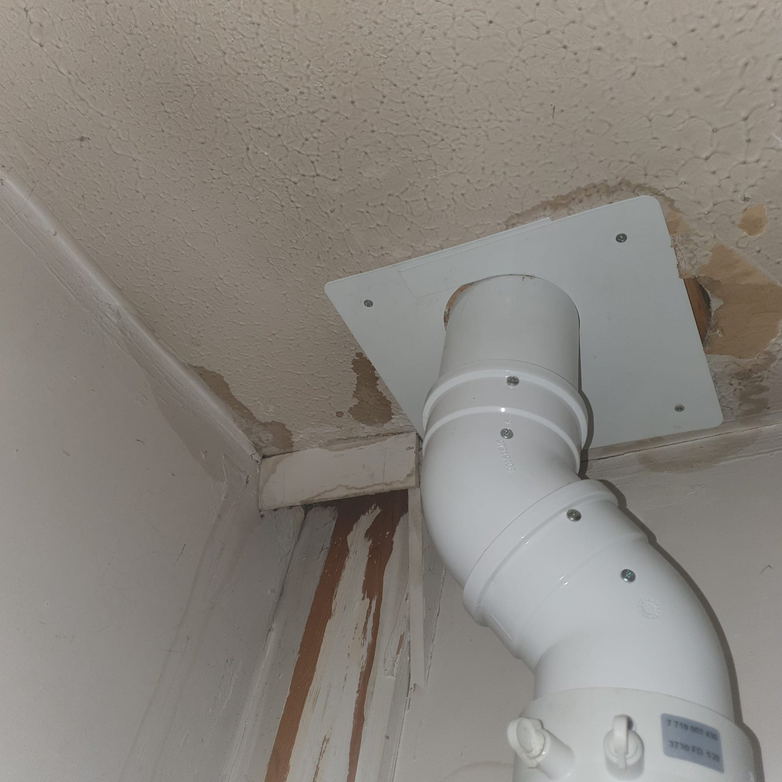 Water staining across a ceiling and down the wall beside a flue outlet inside a property, with the plaster blown where it has been wet