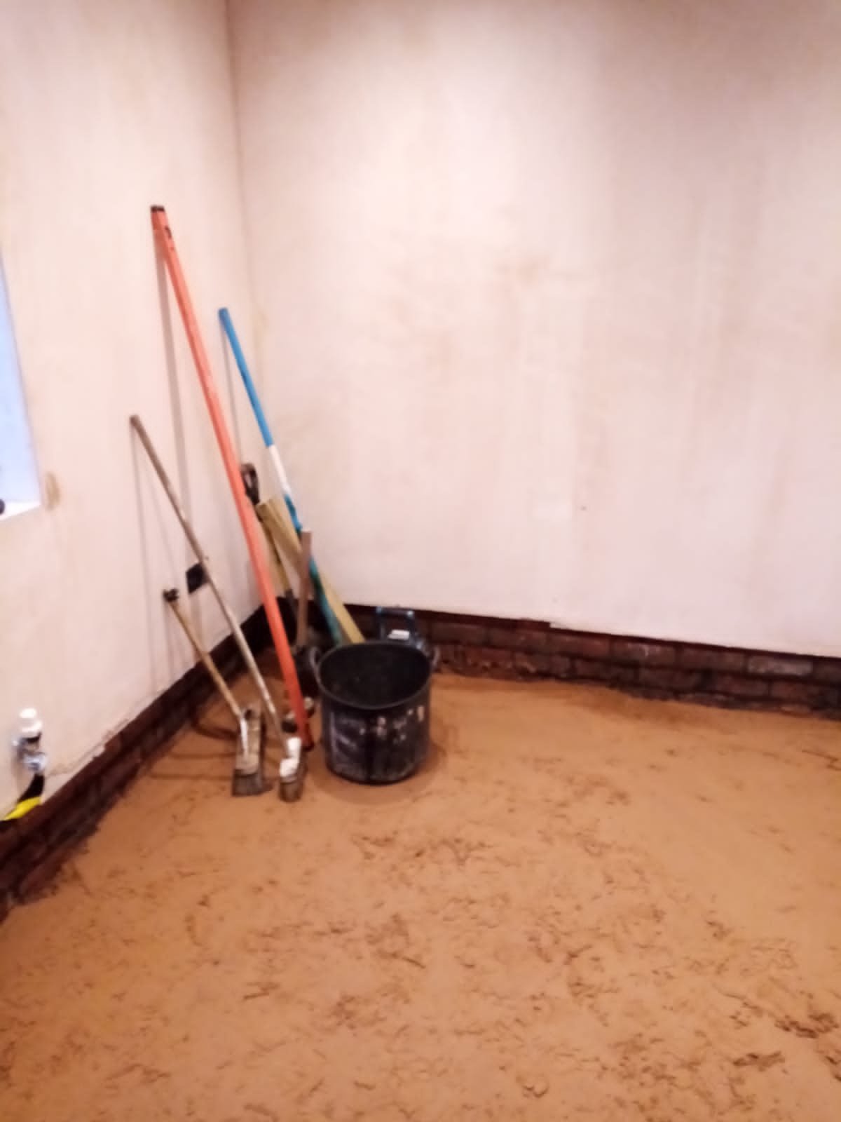Rigid foil-faced insulation boards laid over a black damp-proof membrane in a house in Wirral during a damp floor replacement