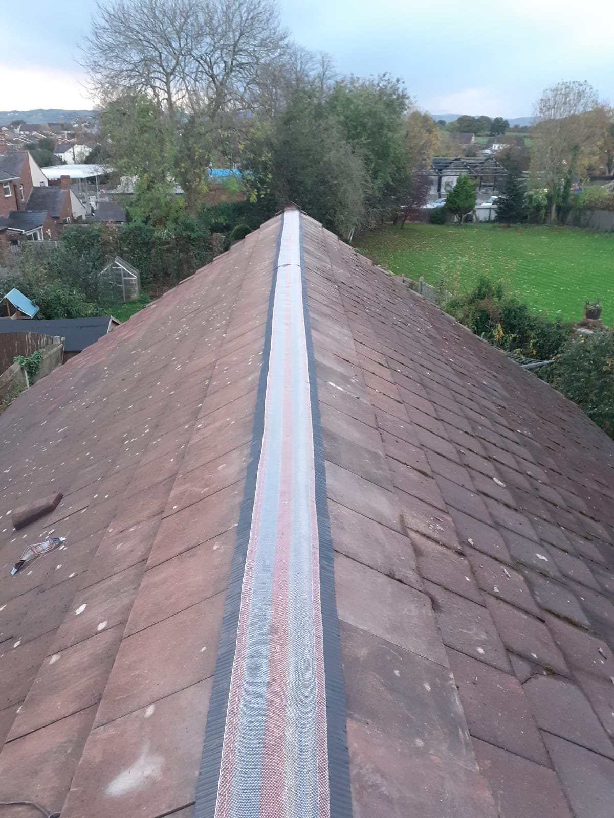 Ventilated ridge roll run out along the full length of a tiled roof ridge before the ridge tiles are refitted