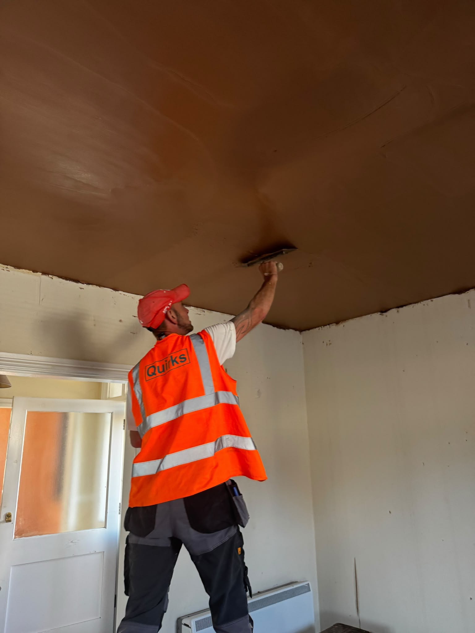 Quirks operative in hi-vis rendering a ceiling during a plastering and rendering job