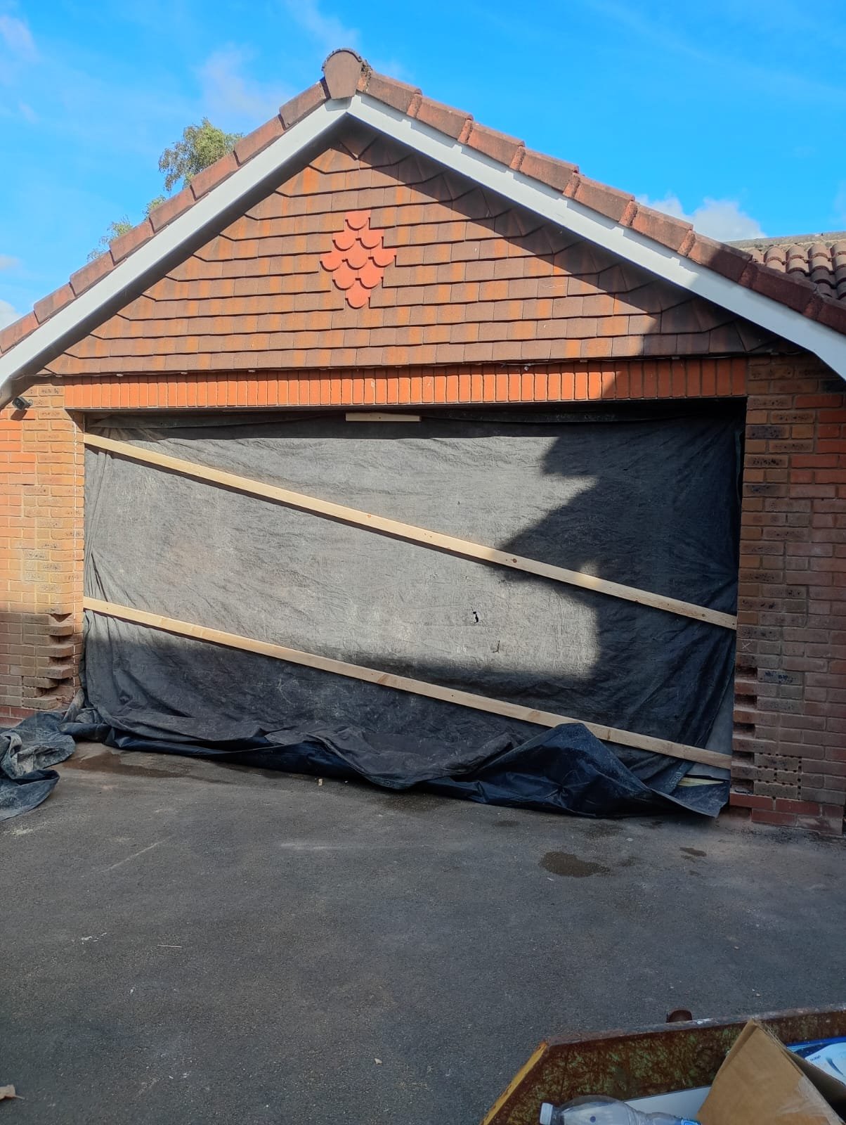 Detached double garage with both up-and-over doors removed and the opening sheeted over during conversion works