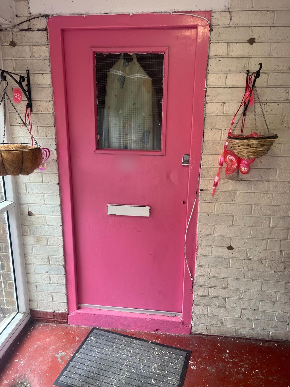 Painted timber flat entrance door with a wired-glass panel, standard letterplate and no door closer, before replacement with a fire door