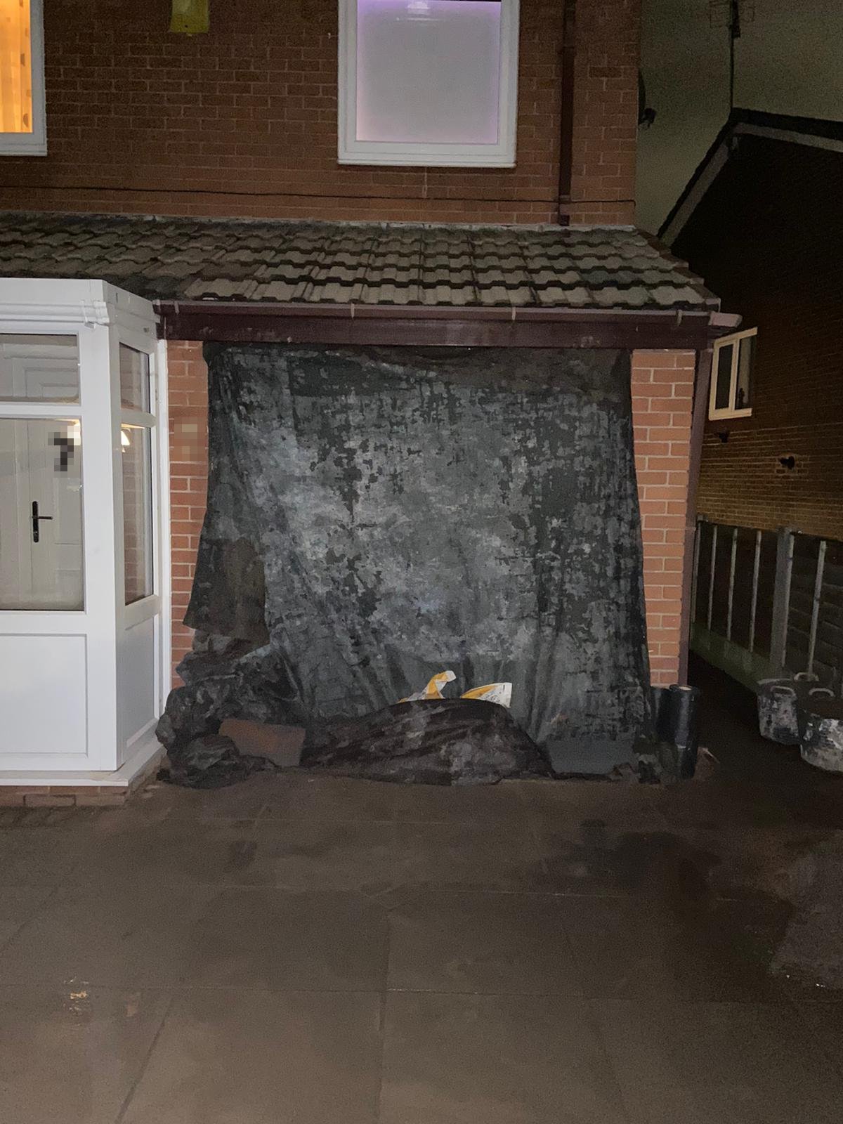 Garage door removed from an integral garage with the opening sheeted over during a garage conversion