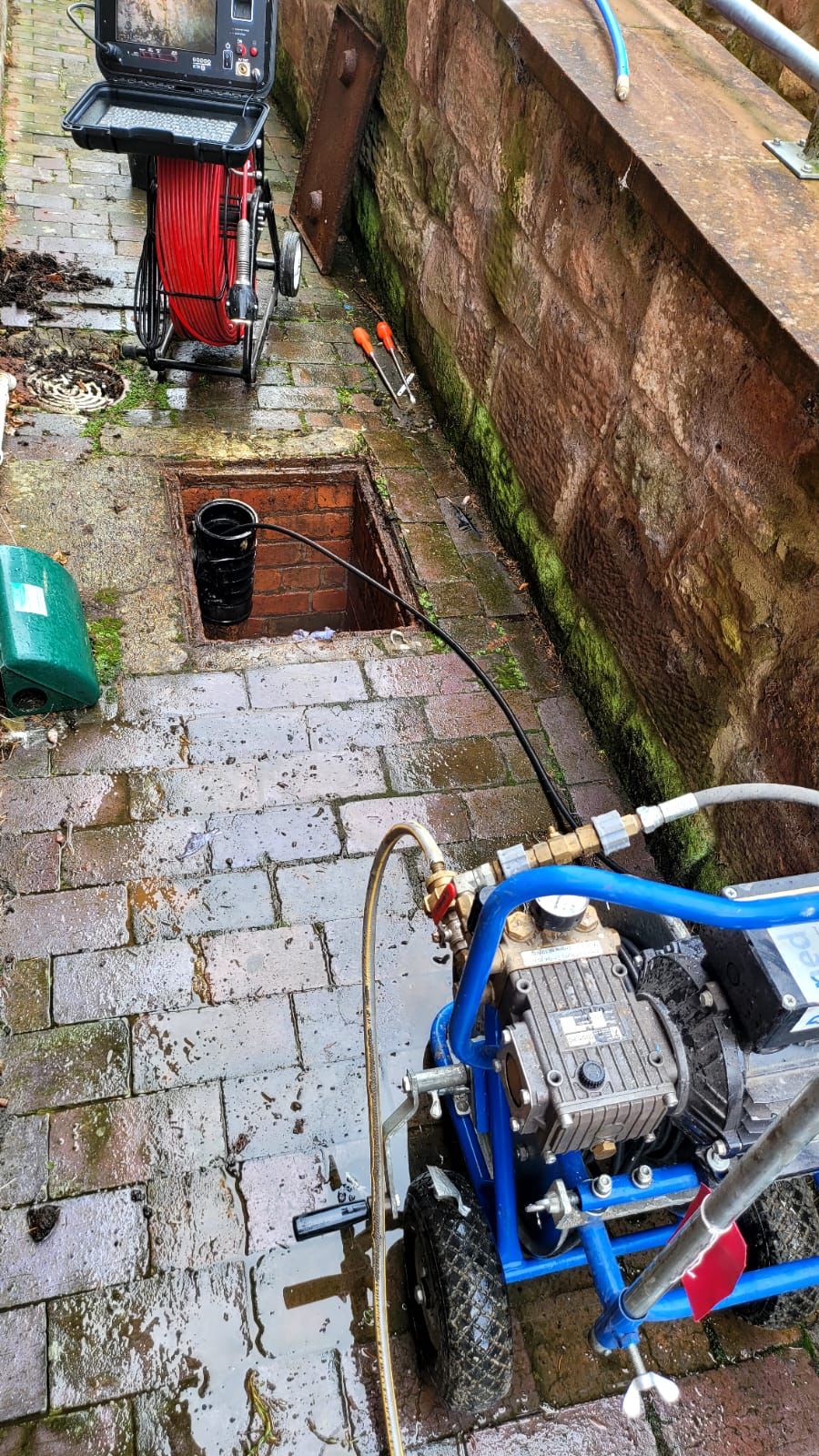 Drain jetting unit and CCTV survey camera set up at an open inspection chamber