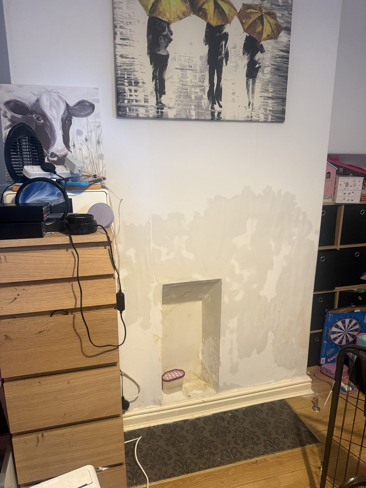 Damp staining and salt marks on a chimney breast around a blocked-up fireplace opening