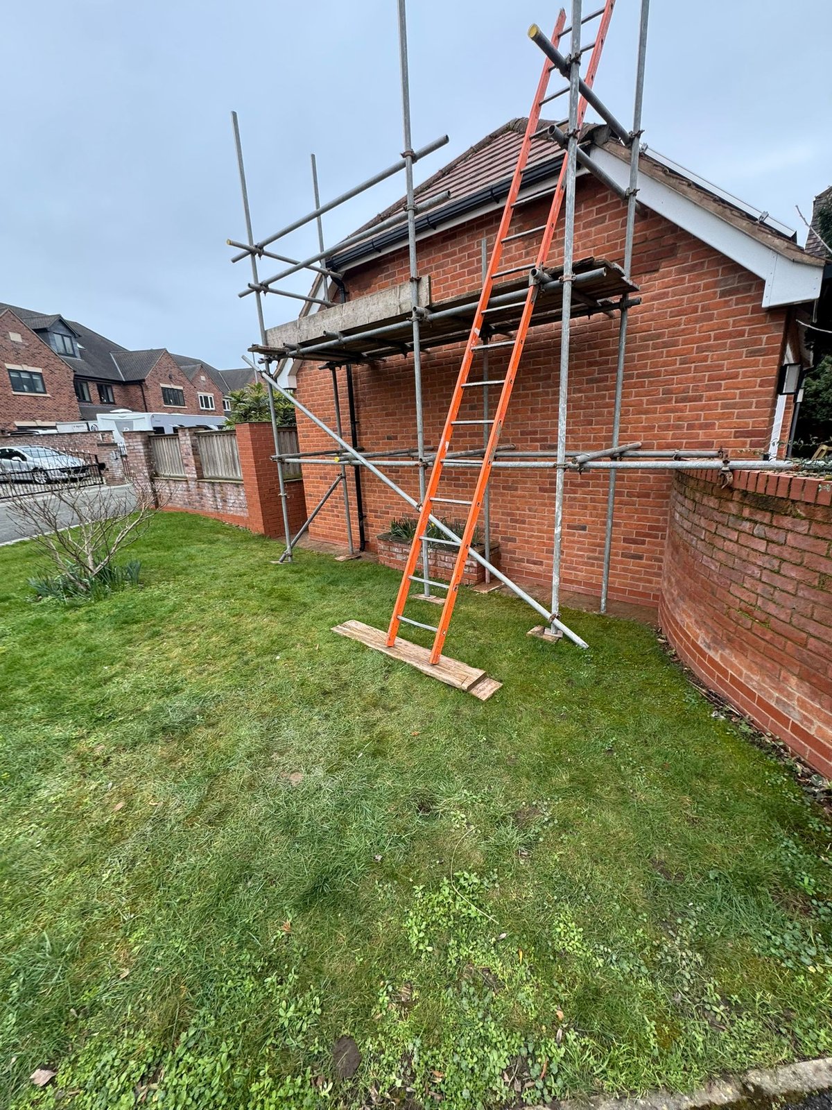 Scaffold erected to the gable of a detached brick house for roof works during a garage conversion