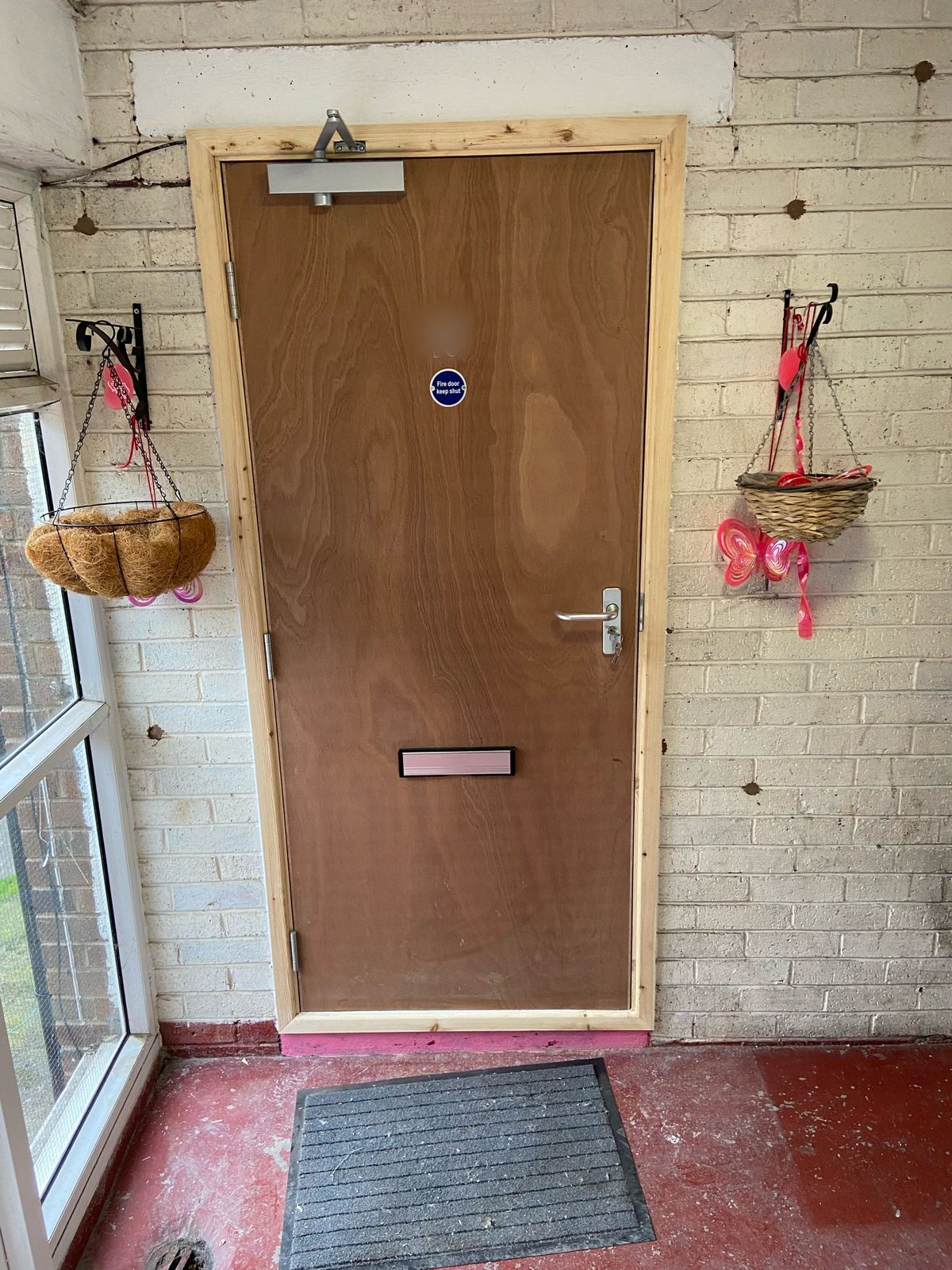New plywood flush FD30 fire door set to a flat entrance with overhead closer, fire-rated lever handle, letterplate and fire door keep shut sign, left undecorated