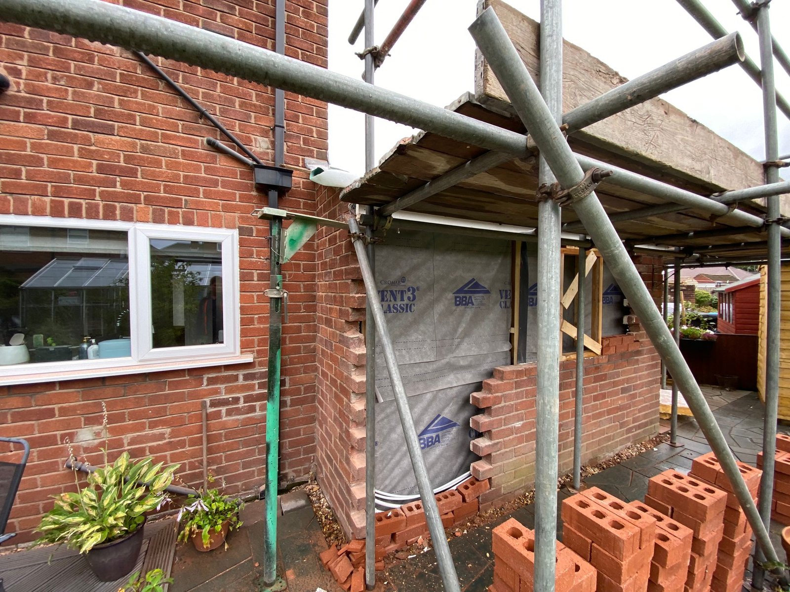 New door opening formed in the side wall of a garage during conversion, with breathable membrane behind and brickwork toothed in around the reveal