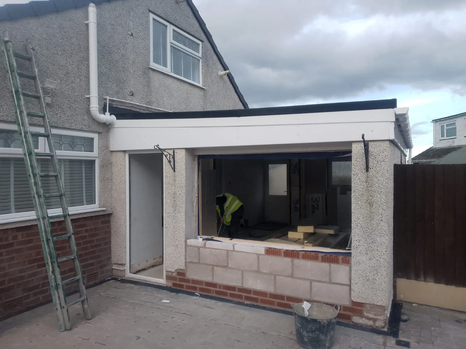 New blockwork and brick infill wall being built in the former garage door opening