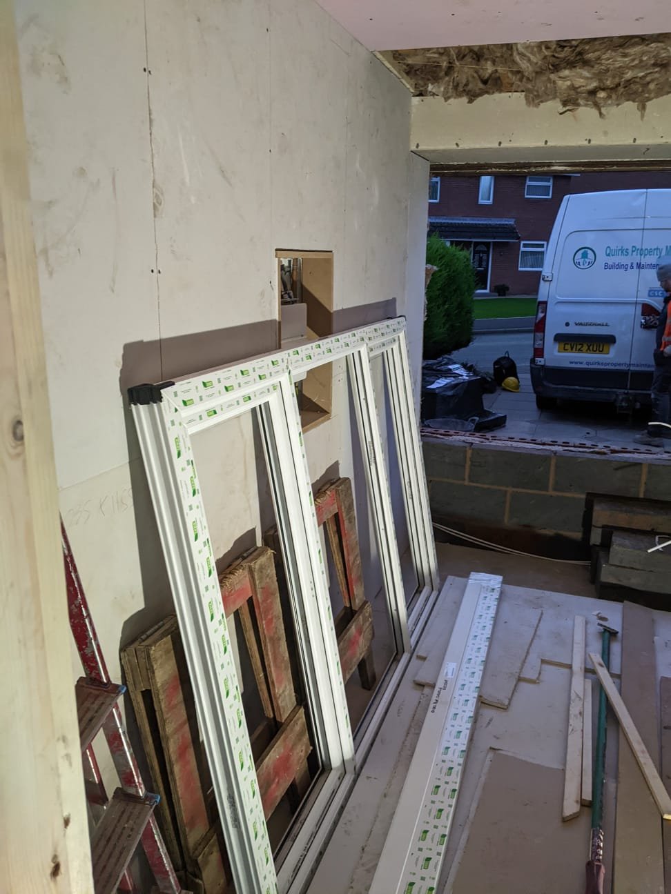 Garage door opening blocked up internally with new UPVC window frames stacked ready for installation