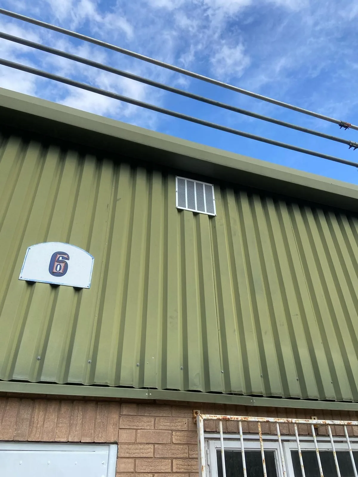 Steel-clad industrial unit elevation with a new louvre vent fitted