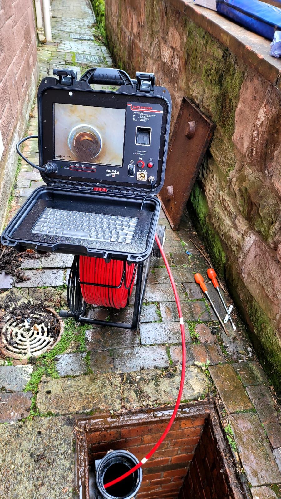 CCTV drain survey camera fed into a drain from an inspection chamber