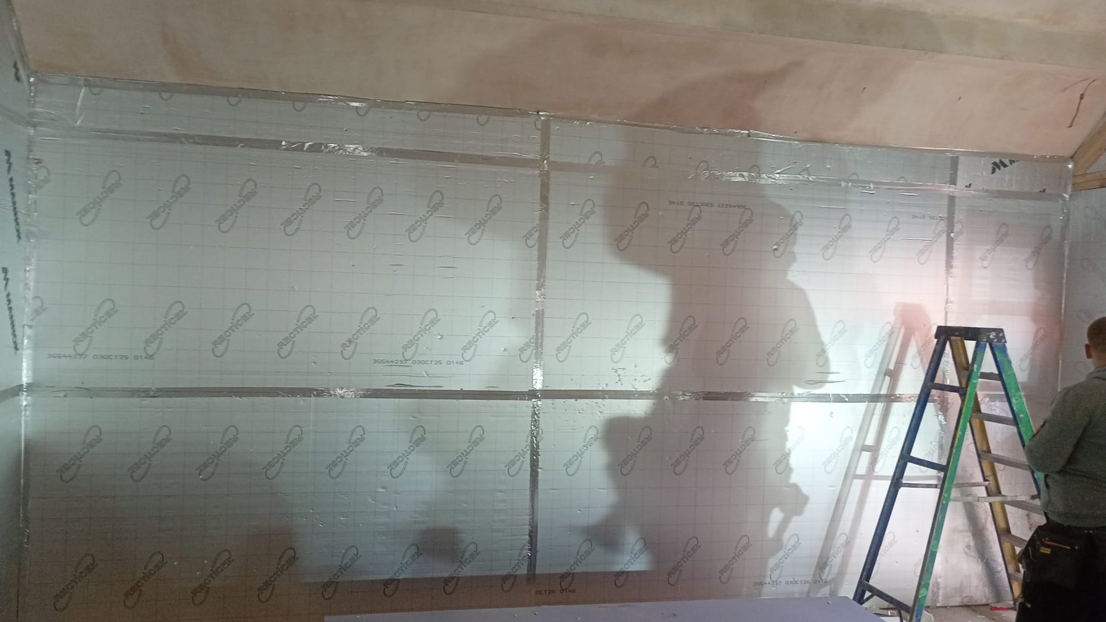 Rigid PIR insulation boards fixed over stud framing with taped joints to maintain thermal continuity
