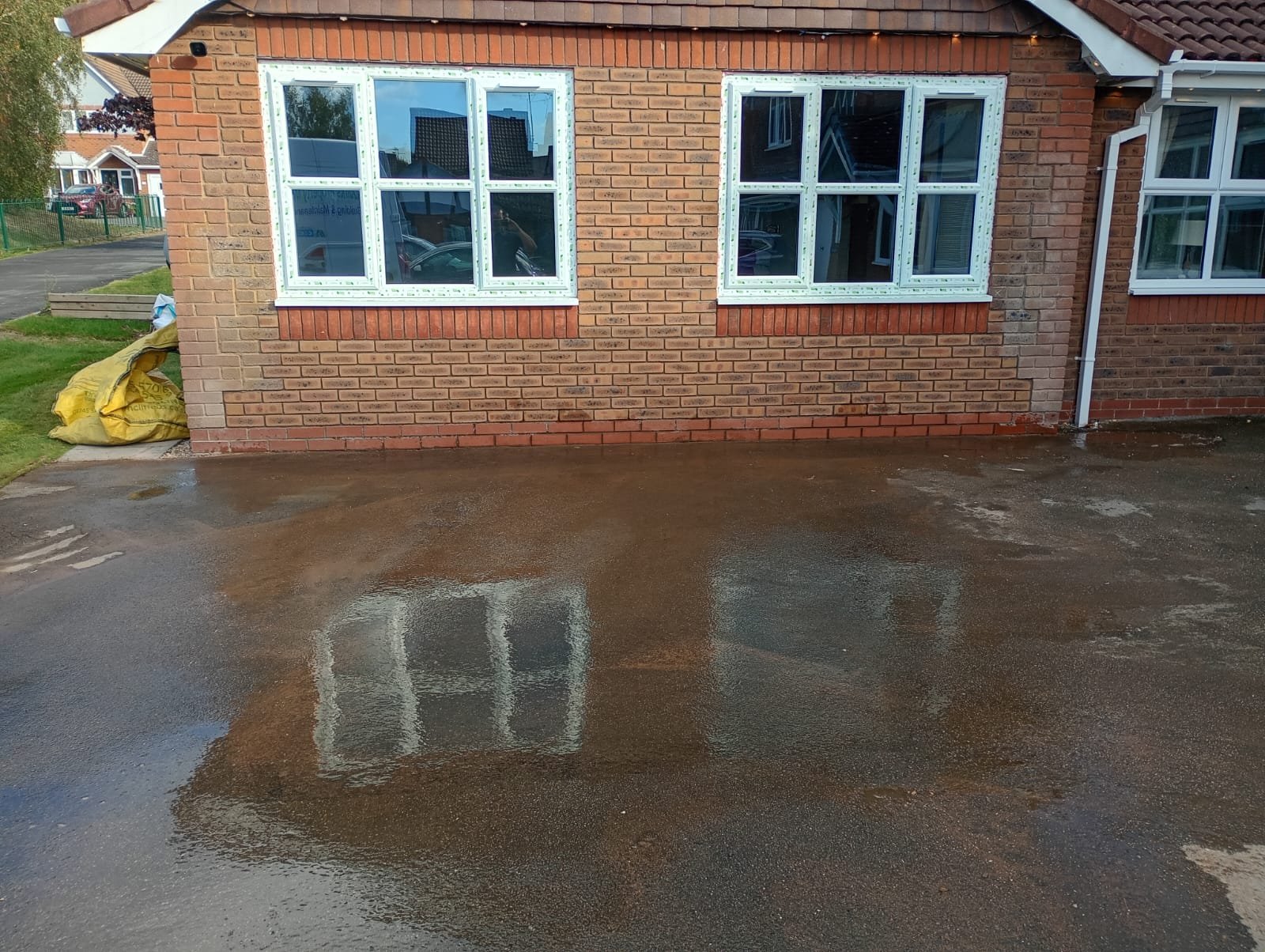 Front elevation of a converted detached double garage with two new UPVC windows installed where the garage doors had been