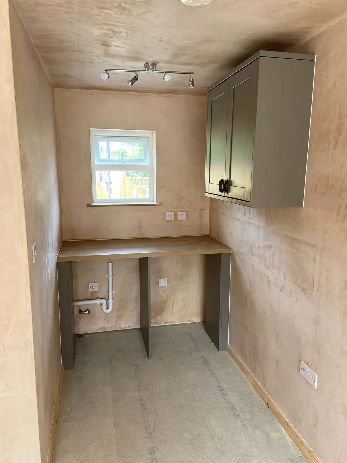 Garage converted to a utility room with worktop, wall unit and plumbing for appliances