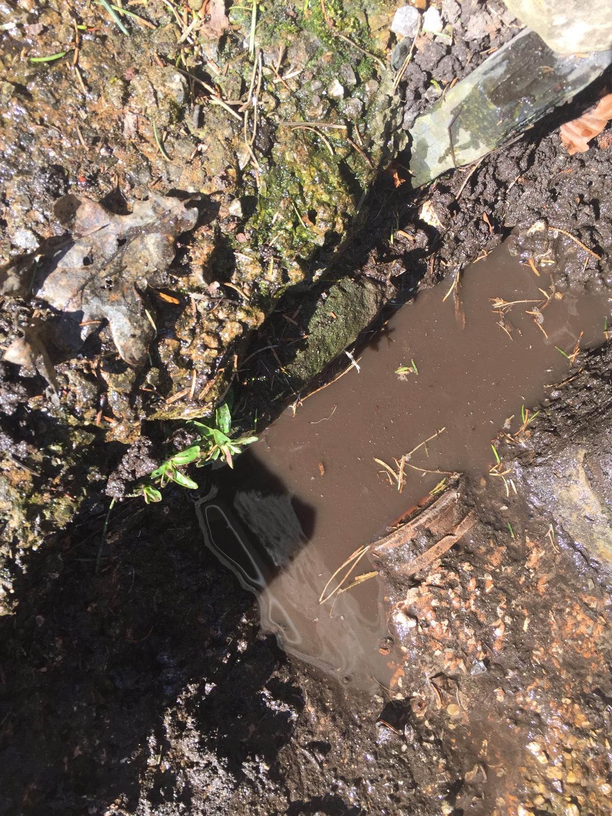 Excavated drain with water standing at an open pipe joint
