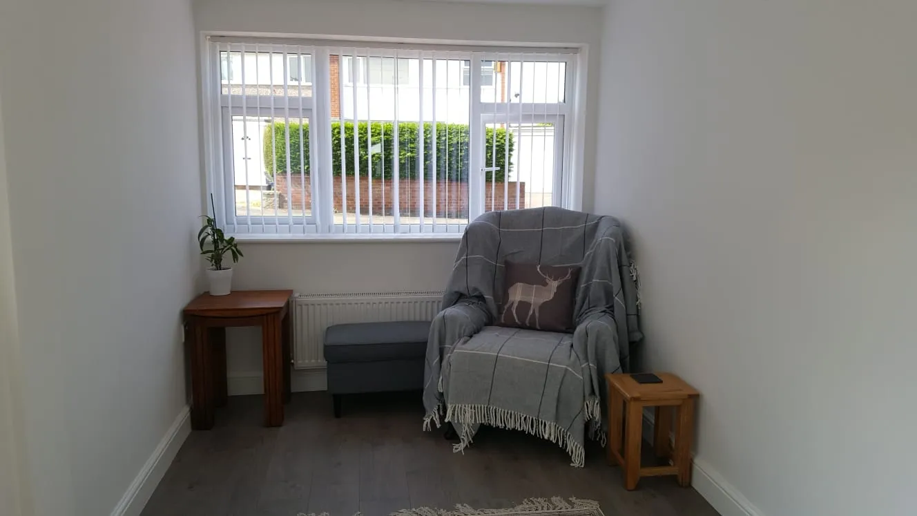 Finished garage conversion used as a sitting room, with new window, radiator and laminate floor