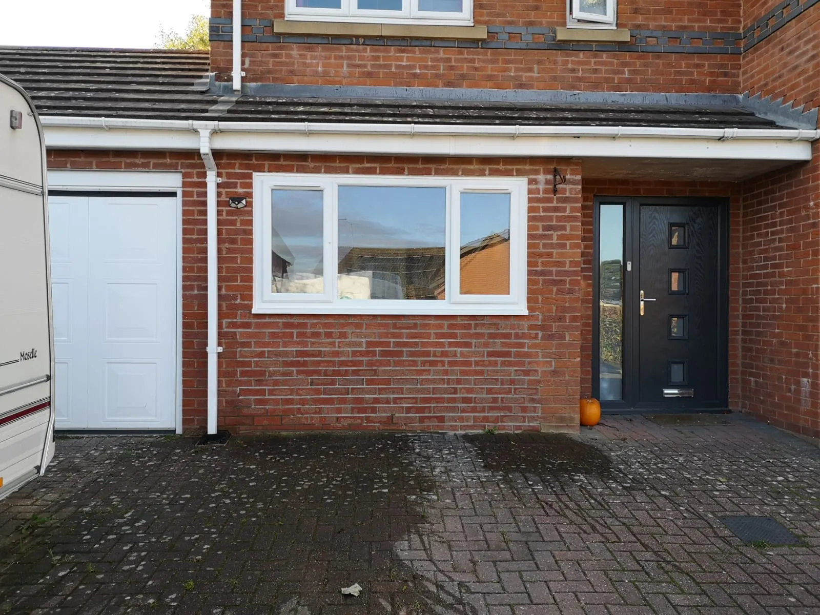 Former garage door opening bricked up to match the house, with a new window fitted