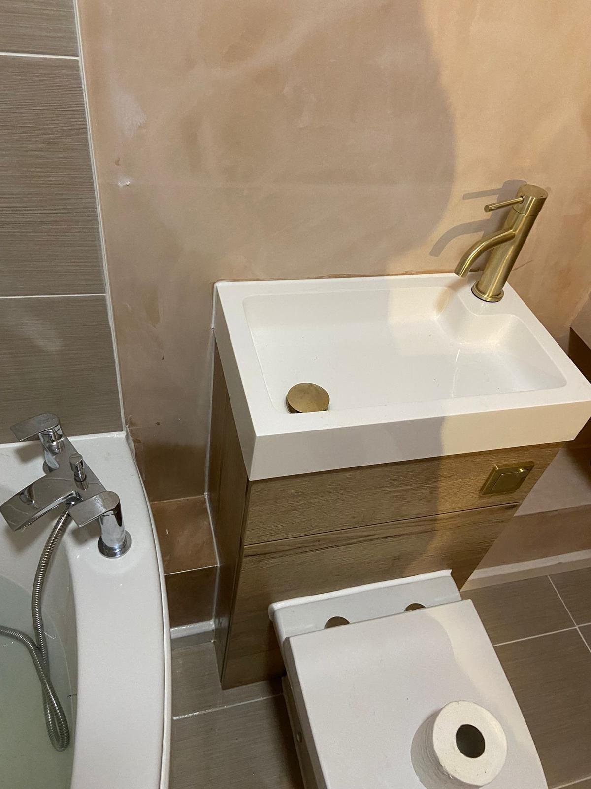 Bathroom basin on a vanity unit beside a wall-hung WC in a converted garage bathroom