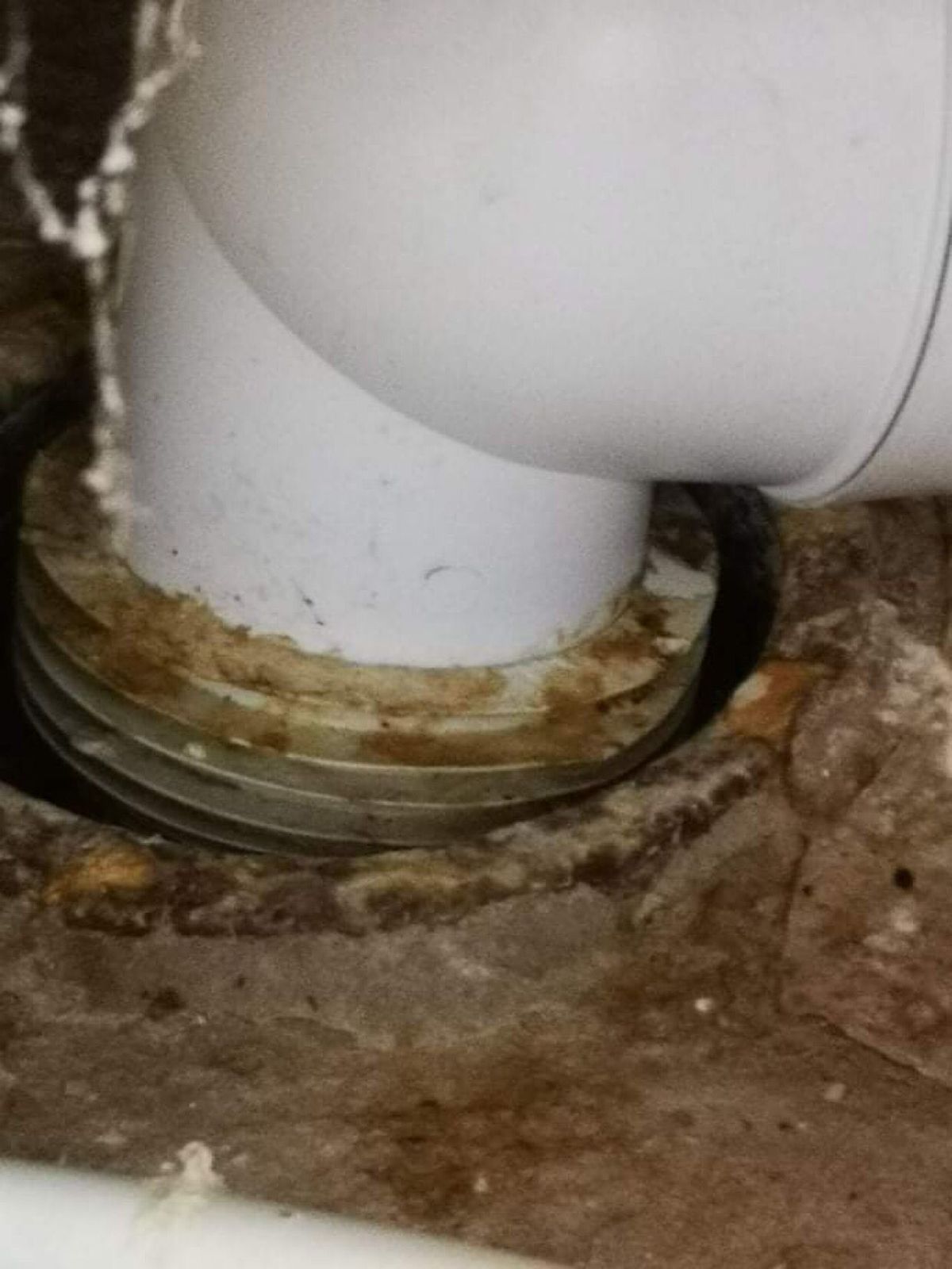 Toilet pan connector into the soil pipe, stained where it has been leaking