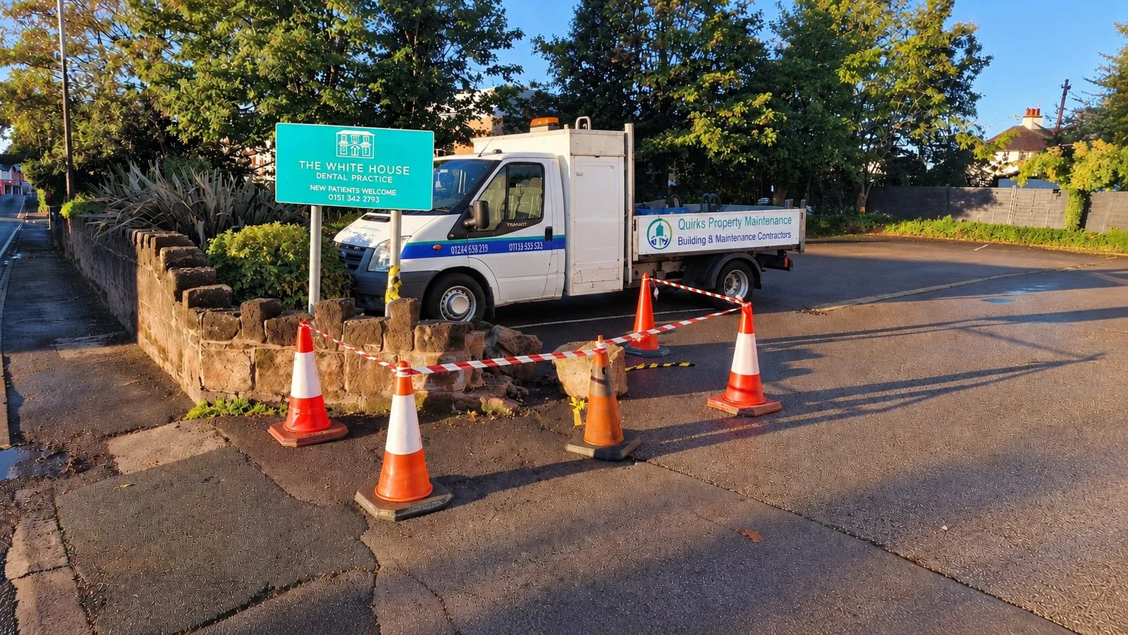 Collapsed boundary wall coned off at a commercial premises with the Quirks truck on site