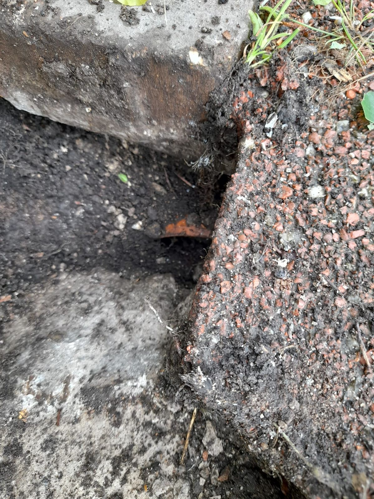 Ground opened beside paving over a broken clay drain
