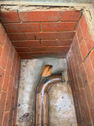 Brick inspection chamber with new concrete benching around the channel