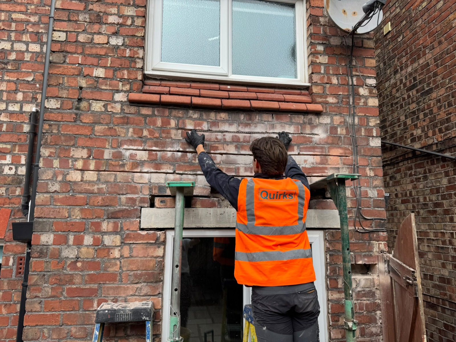Quirks Property Maintenance operative installing helical crack stitching bars into brickwork as part of a structural wall repair.