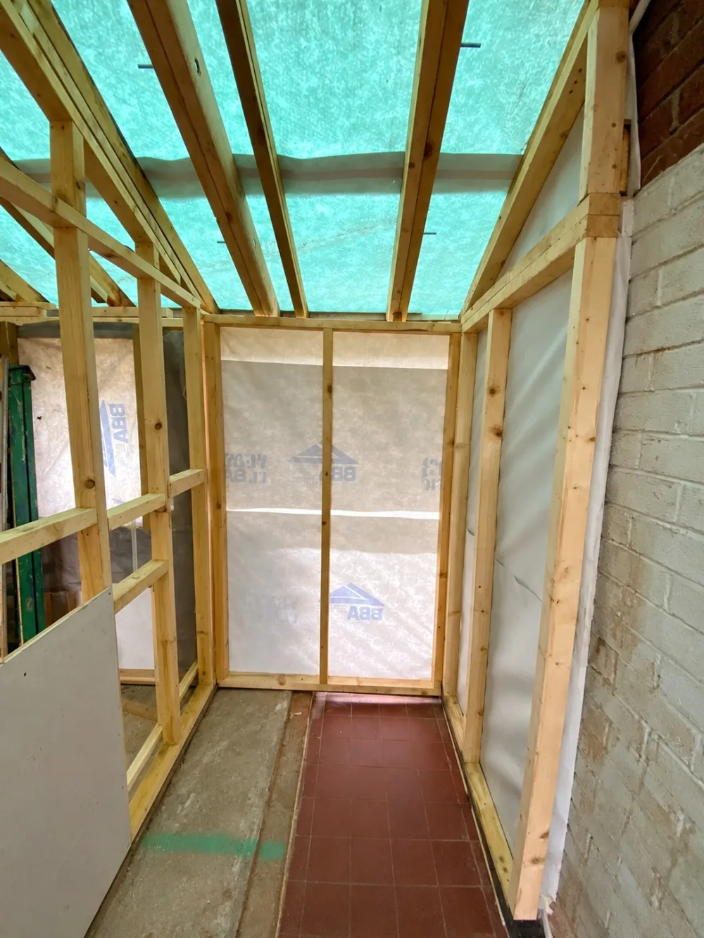 Garage conversion in Chester: timber stud walls with breathable membrane, and the former back door opening framed and built up ready for a new window